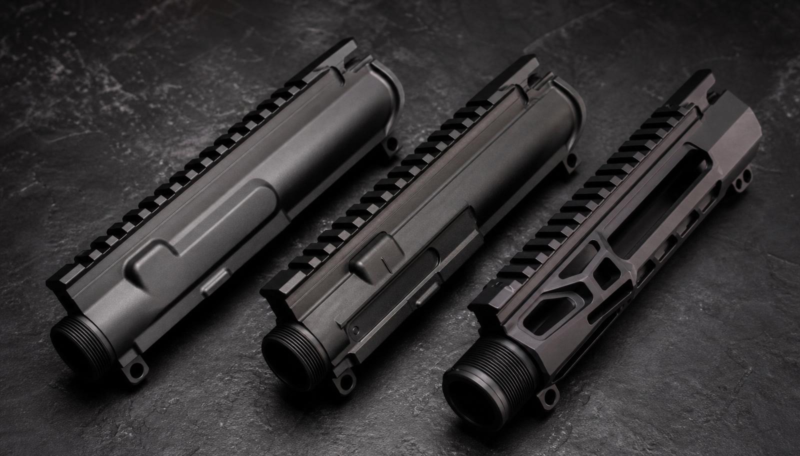 Three AR-15 upper receivers side by side on dark slate: an Aero Precision style, a BCM style, and a Radian style with skeletonized machining.